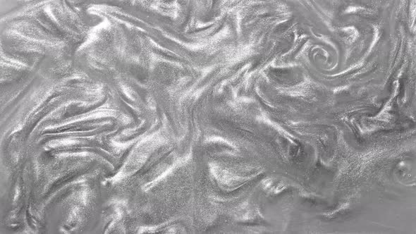 Silver glitter metalic fluid liquid motion background. Shine gray color paint. alt