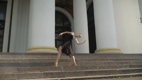 Camera Approaches To Slim Confident Elegant Ballerina Dancing on Urban Stairs alt