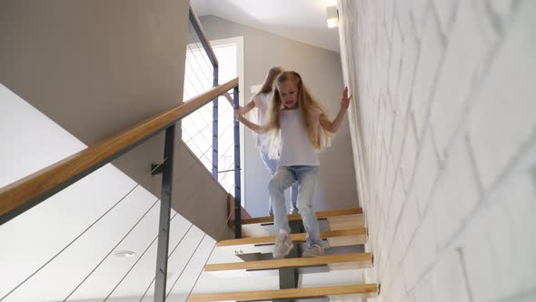 Sisters Running Down Stairs at Home