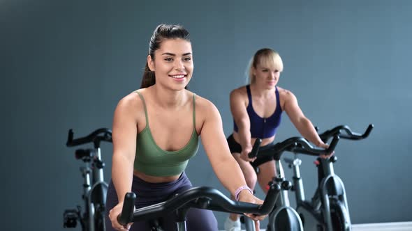 Athletic Woman Spinning Pedals of Exercise Bike Enjoying Cardio alt