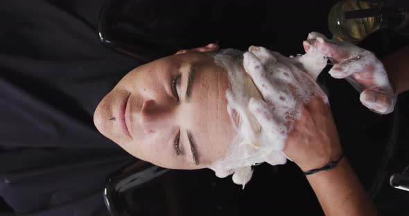 High angle view woman having her hair washed by a hairdresser alt