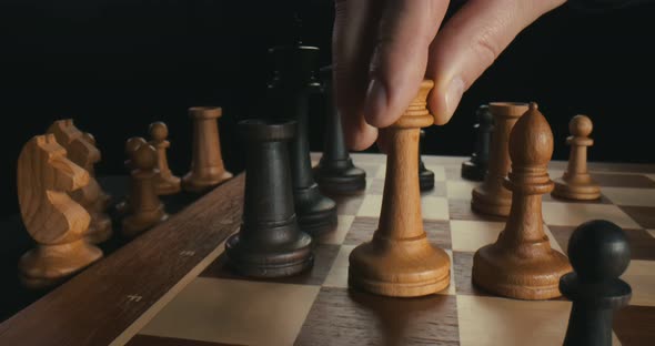 Close Up of Male Hand Moving White Queen Defeating Black King, Checkmate alt