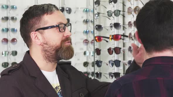 Mature Male Customer Talking To the Optometrist While Choosing New Glasses alt