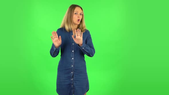 Fair Woman Is Strictly Gesturing with Hands Crossed Making X Shape Meaning Denial Saying NO. Green alt