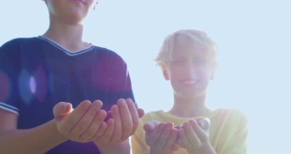 Cheerful Boys Holding Berries in Hands Outdoors alt