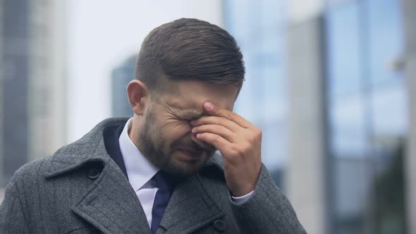 Handsome Man Feeling Pain in Forehead and Rubbing Eyes, Overworking, Tiredness