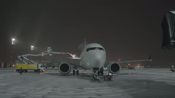 De-icing Tail Wings of the Airplane Before Night Departure alt