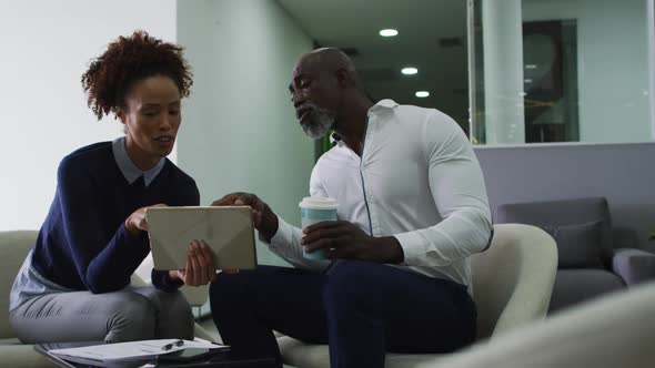 Diverse male and female business colleagues talking, woman holding digital tablet in office alt