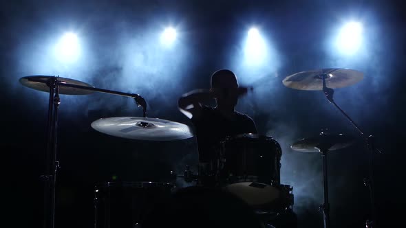 Energetic Music in the Performance of a Professional Drummer. Black Smoky Background. Silhouette alt