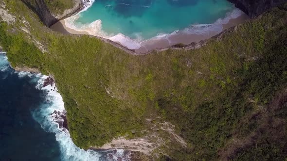 Dramatic aerial view flight high bird's eye view drone shot ofer edge cliff big waves Kelingking Be alt