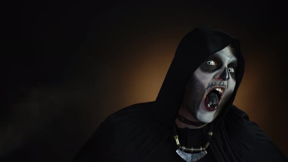 Creepy, Crazy Man with Skeleton Makeup in Hood Making Angry Faces, Shaking Head, Trying To Scare alt
