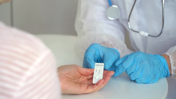 Doctors Hands Give Rapid Antigen Test for Covid19 to Patient in Clinic alt