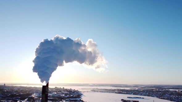 Chimneys of a Factory or Power Plant Produce Smoke at Sunrise Aerial View From a Drone