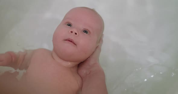 Beautiful Portrait of Newborn Baby During Bathing alt
