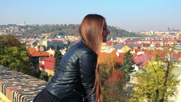 Young Beautiful Woman Walks in Autumn Park and Relax - Panorama of City alt