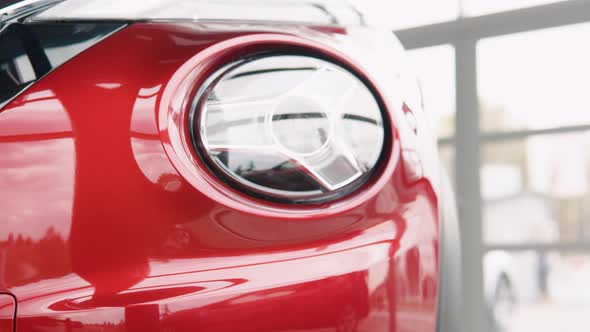 Close Up of Details of Headlights of Anonymous Prestigious Red Modern Car alt