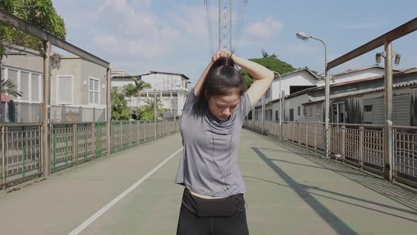 Beautiful young Asian woman stretching and warming before running a Jogging workout.