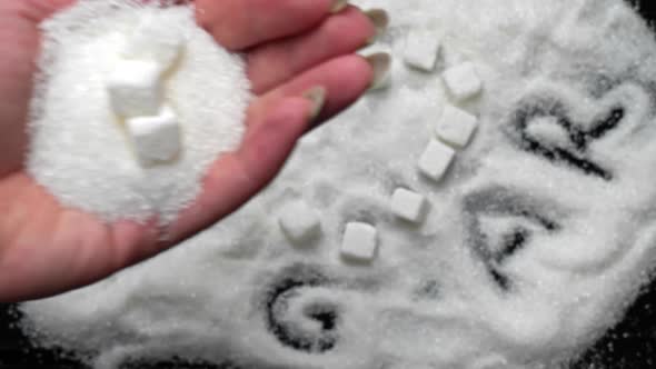 White Sugar Cubes in the Shape of a Heart Lie on Sugar Sand alt