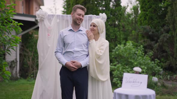 Loving Interracial Couple Standing at Wedding Altar Smiling Looking at Each Other with Love alt