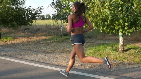 Morning Jogging Beautiful Girl on a Country Road. Slow Motion alt