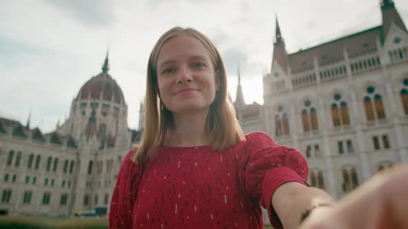 Tourist Woman Takes Selfie Photo or Film with Budapest Parliament Building