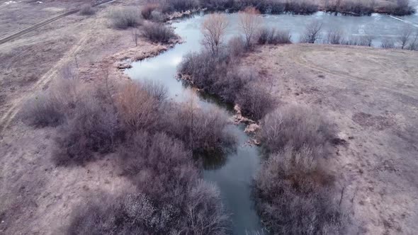 Aerial view of the river channel in the first days of spring.