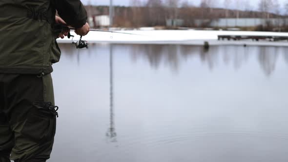 Unrecognizable Man Fishing in Lake at Dawn