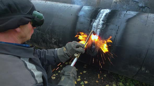 The Welder Cuts Large Metal Pipes with Ocetylene Welding