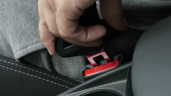 Passenger in car connects 3-point seat  belt on bracket 4K video alt