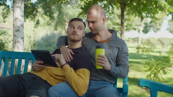 Loving Same-sex Male Couple Resting in Park alt