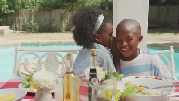 Happy family eating together at table alt
