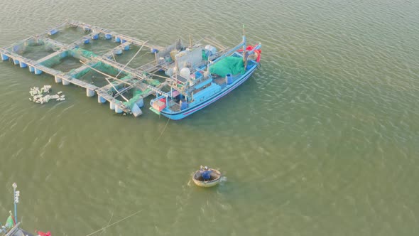 Drone view of fisherman sailing on a basket boat to the fish farm, Nha Trang city, Khanh Hoa provinc alt