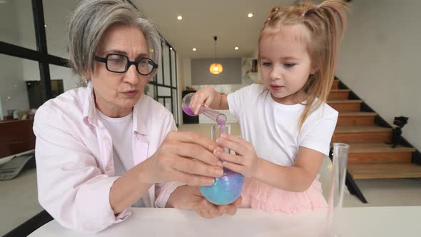 Attentive Old Grandma Assist Grandkid in Funny Scientific Experiments alt