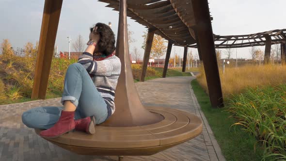 Autumn Day Heat Western Caucasian Middle-aged Woman Riding in Circle on Carousel alt