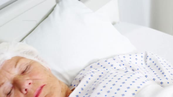 Senior woman patient sleeping on bed alt