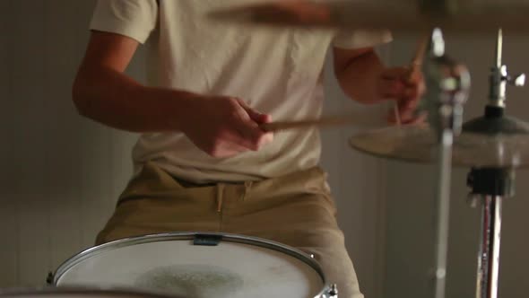 Drummer practicing rudiments on his drum kit. alt