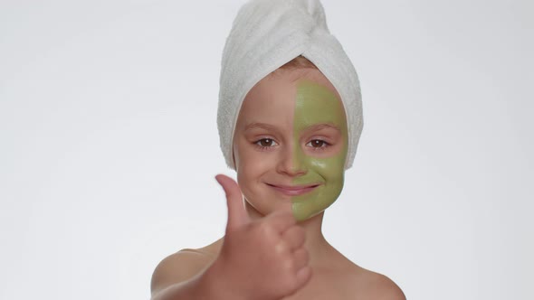 Beautiful Smiling Child Girl Kid in Towel on Head Applying Cleansing Moisturizing Green Mask on Face alt