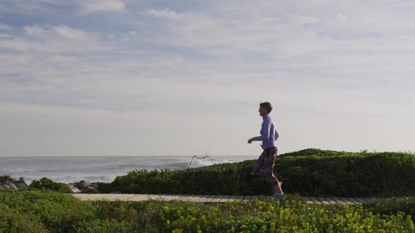 Caucasian woman enjoying free time by the sea on sunny day running path alt