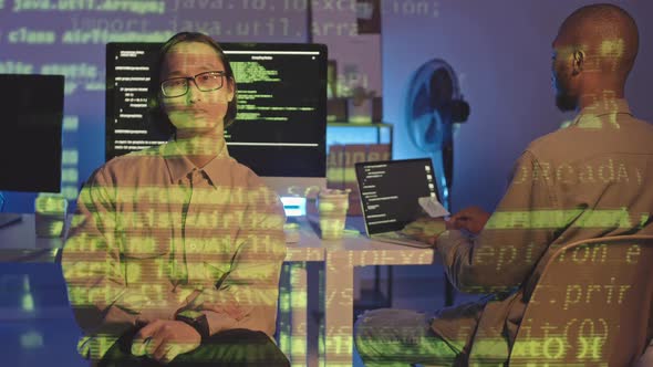 Portrait of Tired Asian Programmer at Dark Office alt