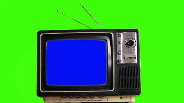A Vintage TV Set Turning On Blue Screen Against Green Background. 4K.