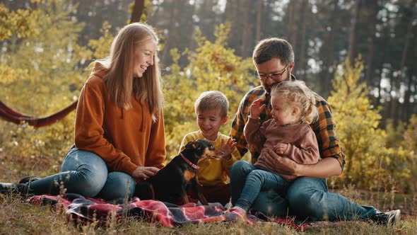Happy Family with Children and a Dog in an Autumn Park alt