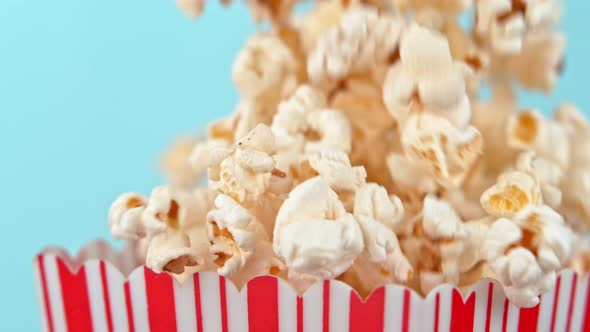 Falling Popcorn in Super Slow Motion on Blue Background alt