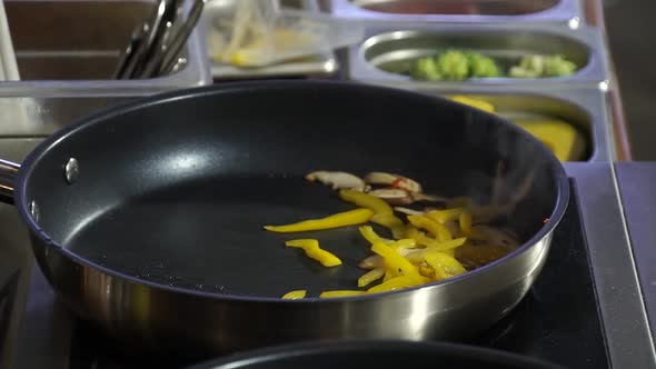 Cook Frys in a Frying Pan a Mixture of Peppers Mushrooms and Squid