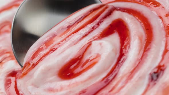 Yogurt with berry jam in spoon, blueberry whipped cream, extreme close up alt