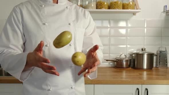 Chief-Cooker Juggles A Potatoes In A Kitchen