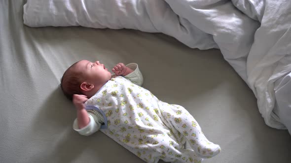 Newborn Baby Lies on the Bed and Shudders alt