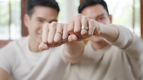 Young Asia Gay couple feeling happy showing ring at home..