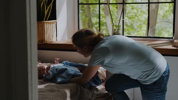 Adorable Newborn Baby Picks Up the Back in Child Crib in Cozy Warm Dark Room alt