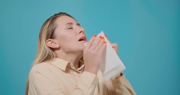 Lady with Long Fair Hair Sneezes Into White Paper Napkin alt