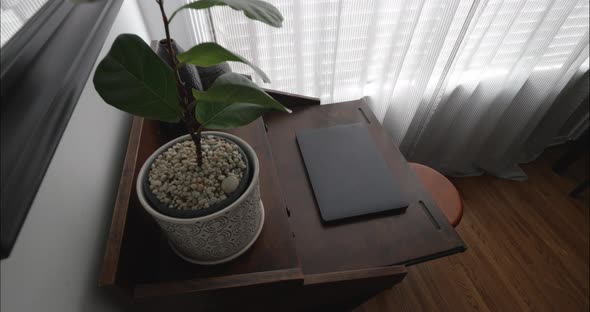 Home office with modern decor and closed laptop on desk. Steadicam vertically downwardement. alt